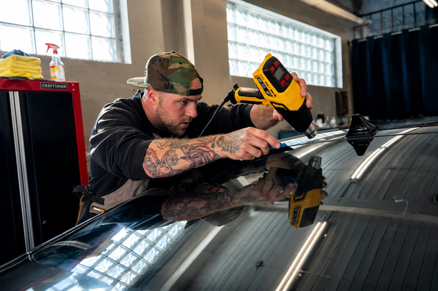 Technician working on a vehicle roof at Ocean County Reconditioning