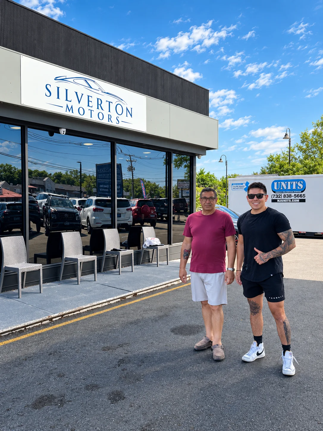 Two men standing outside Silverton Motors on a sunny day